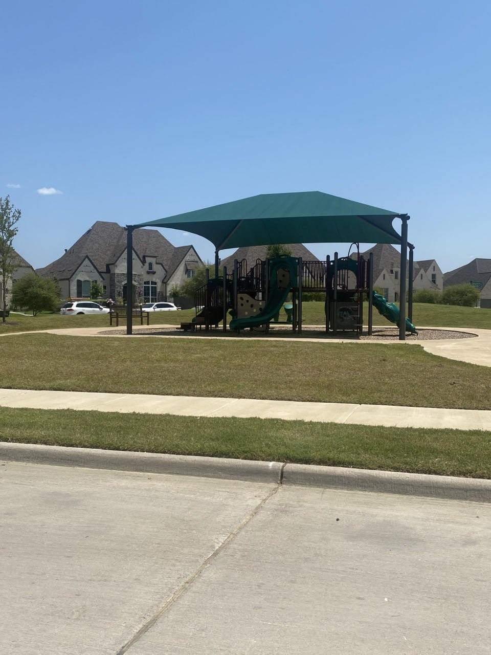 Shaded M3 Ranch community playground in Mansfield TX with modern play equipment