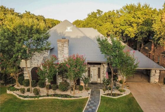 Aerial view of a brick house with a walkway.