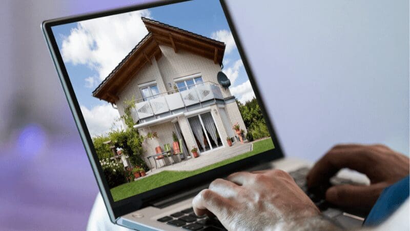 Home with front porch on computer screen of home search portal for buyers on internet