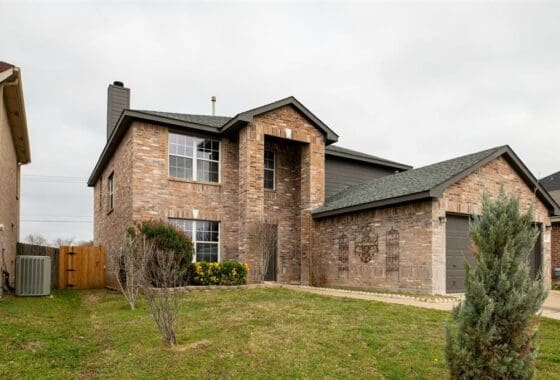 Brick house with a garage and front yard.