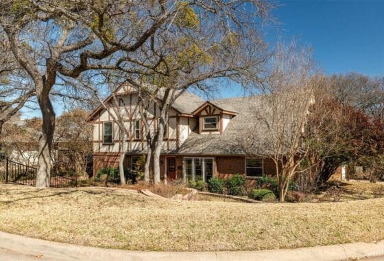 A two-story brick house with a yard.