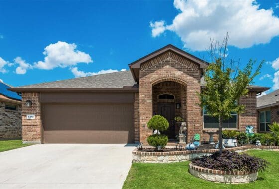 Brick house with a garage and landscaping.