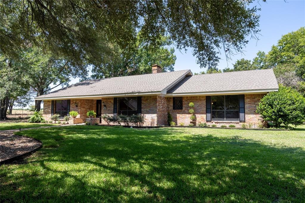 Brick ranch house with green lawn.