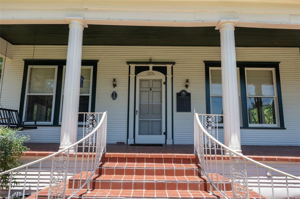 White porch with steps and railing.