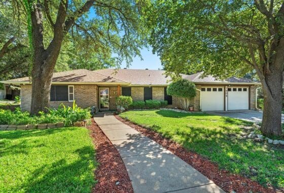 Brick house with a walkway and green lawn.