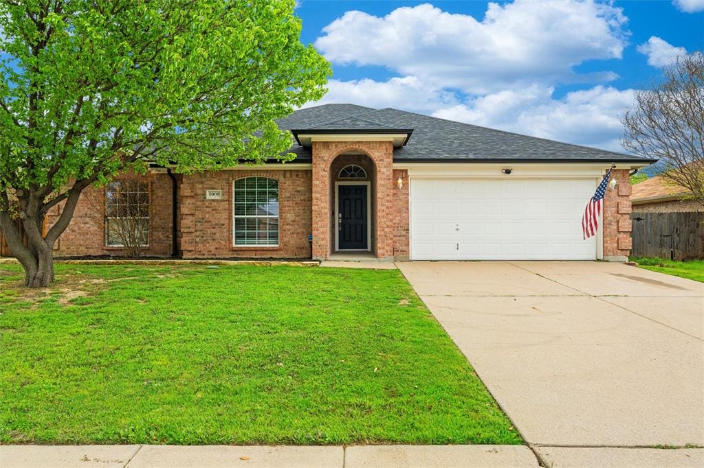 Brick house with green lawn and driveway.