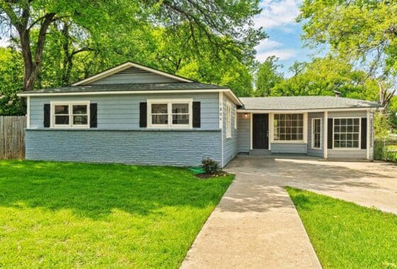 Blue house with green grass and a walkway.