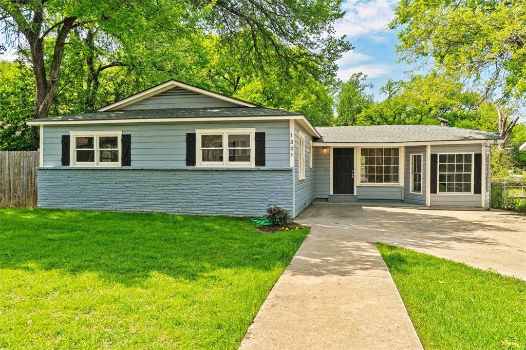 Blue house with green grass and a walkway.