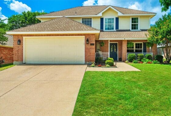 Two-story house with garage and green lawn.