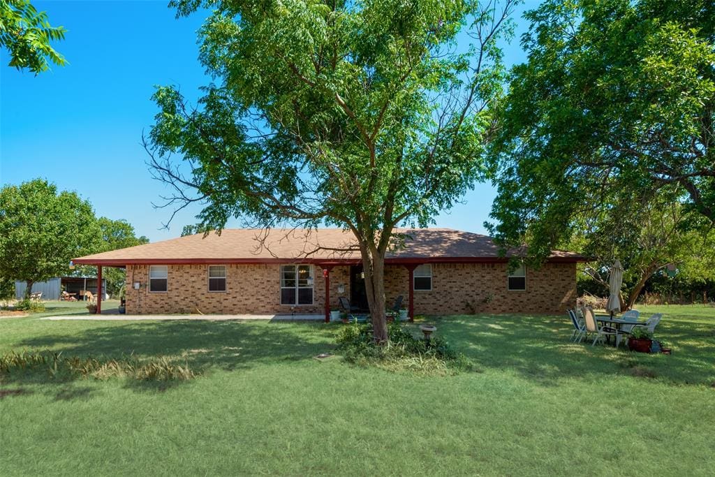 Brick house with trees and green grass.