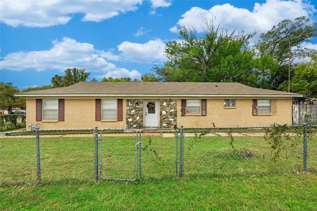 Brick house with stone accents and a fence.