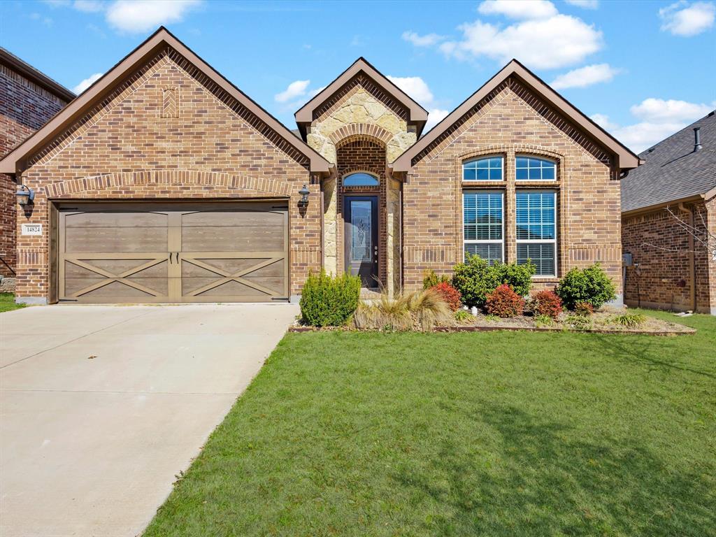 Brick house with driveway and front lawn.