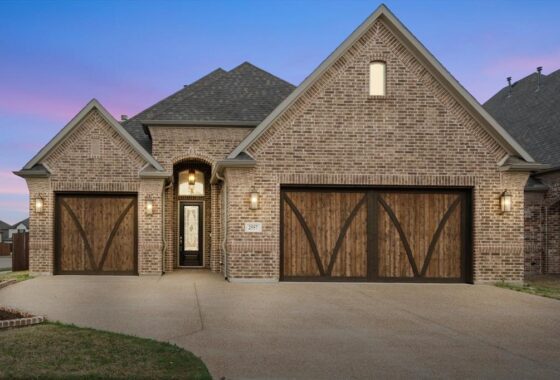 Brick house with wooden garage doors.