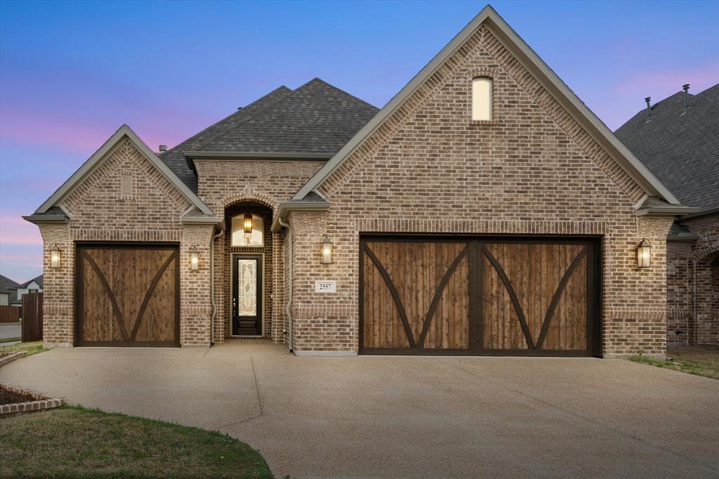 Brick house with wooden garage doors.